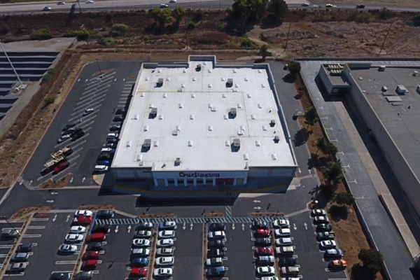 San Diego roofing project showing completed flat commercial roof with clean white membrane for Burlington